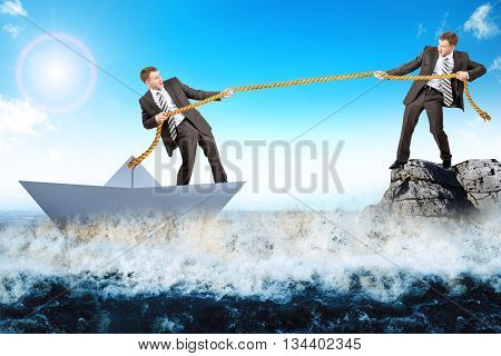 Businessman on rock saving man in paperboat