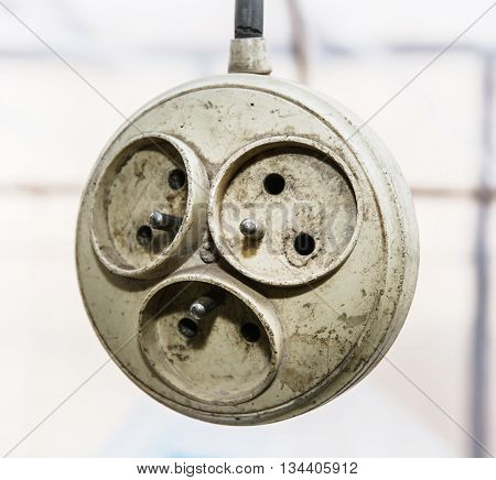 Hanging old dirty multiple electrical outlet. Supply electricity. Power bar.