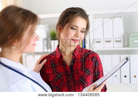 Friendly female doctor touching patient shoulder for encouragement empathy cheering and support after medical examination. Trust and ethics concept. Good news healthcare and medical service concept
