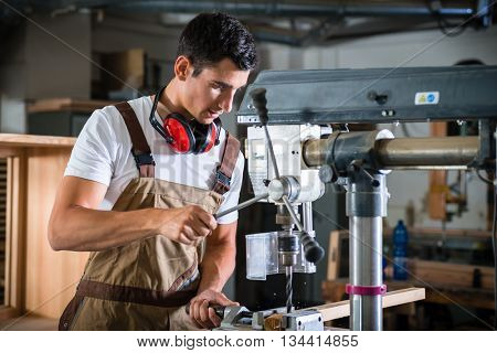 Cabinet maker working on power drill