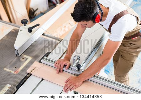 Carpenter or cabinet maker in his wood workshop