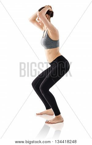Sporty beautiful young woman practicing Uddiyana Bandha technique isolated on white