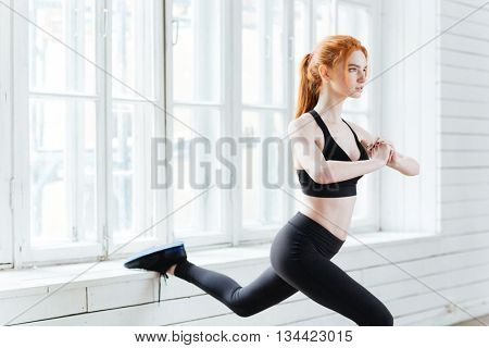 Young beautiful fitness woman doing stretching exercices at the gym