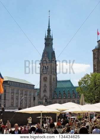 Hamburg Germany - May 22 2008: Town hall of Hamburg - people resting under sunshades in front - view from Jungfernstieg