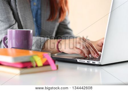Close up view of businesswoman designer or student hands working on laptop. Online distant education writing blog freelance mobile payments working at office or at home concept.
