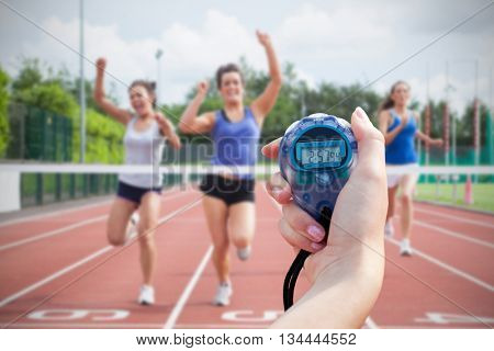 Composite image of a woman holding a chronometer to measure performance of sportswomen