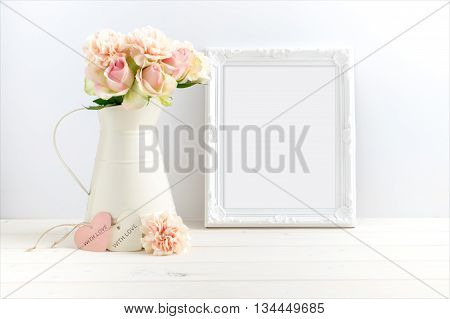 styled stock photograph of cream jug of flowers next to a white ornate frame. You can place your business promotion blog title quote headline or image in the frame.