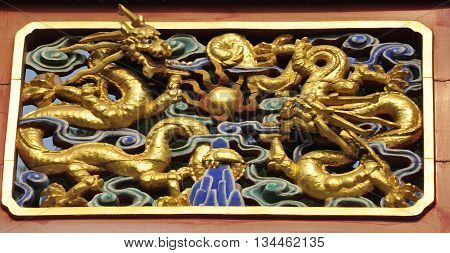 Golden chinese dragon architectural details on a gate within Jingshan Park Beijing China.