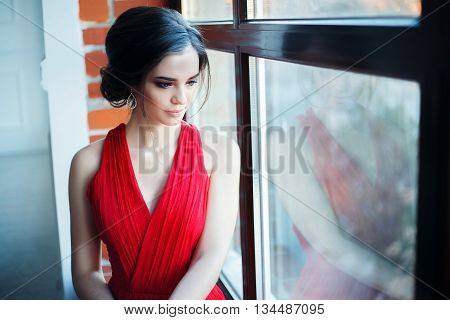 Portrait of Beautiful Sensual smilyng Woman in Fashion Red Dress. Christmas Sales and Shopping concept. Studio shot