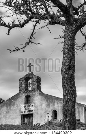 ancient rural church and a tree for a black and white composition