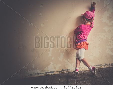 Little four years old girl practicing her salsa dancing moves outside a dilapidated building