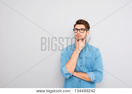 Handsome Ponder Young Businessman In Glasses On Gray Background