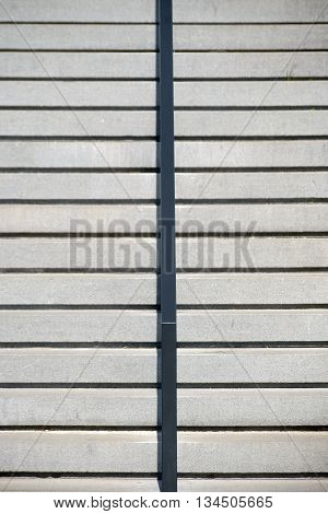 The top view of a staircase made of concrete with railings and stairs.