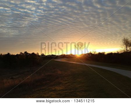 sunset over a country hill with clouds.