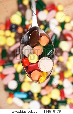 Medical Pills On Teaspoon And Heap Of Colorful Medical Capsules In Background, Health Care Concept