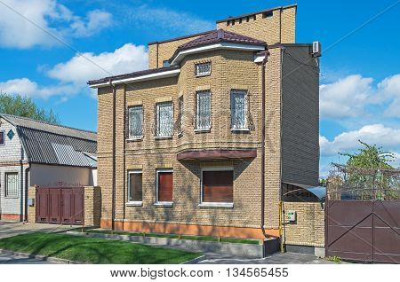 A small brick house covered with a red metal tile