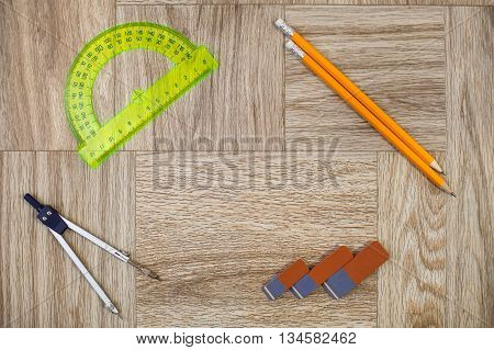 Pencil, Eraser, Circinus And Protractor Ruler On A Wooden Texture