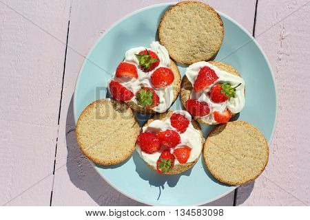 Oat buiscits with cream and fresh strawberries close up