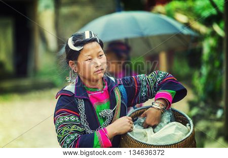 SAPA, VIETNAM - OCTOBER 29, 2012: Hmong women sell souvenirs in Sapa. The Hmongs are known for their colorful clothes and silver jewelry. Hmong women have various clothes colours and style