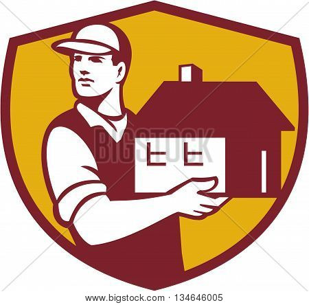 Illustration of a house mover handling holding house looking to the side set inside shield crest on isolated background done in retro style.