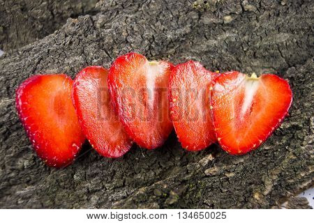 Slices of strawberry on wooden background. Eco-friendly food