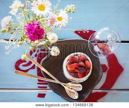 Strawberry dessert with two spoons and a vintage table.