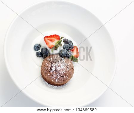 Chocolate fondant served with bilberries strawberries and ice cream.