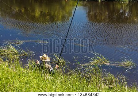 The river Kargat Novosibirsk oblast Siberia Russia - June 12 2016: a fisherman catches a fish on the river on a float