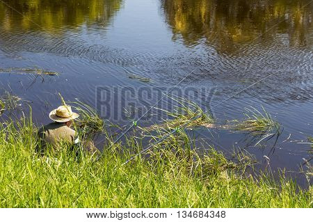 The river Kargat Novosibirsk oblast Siberia Russia - June 12 2016: a fisherman catches a fish on the river on a float