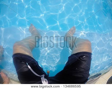 man sit in swimming pool with sunshine daylight