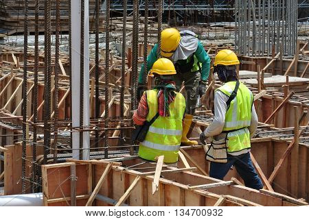 MALACCA, MALAYSIA -MARCH 13, 2016: Construction workers at the construction site in Malaysia. All of them is required to wear adequate safety equipment during works to make sure their safety.