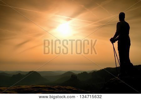 Silhouette Of Tourist With Poles In Hand. Sunny Spring Daybreak