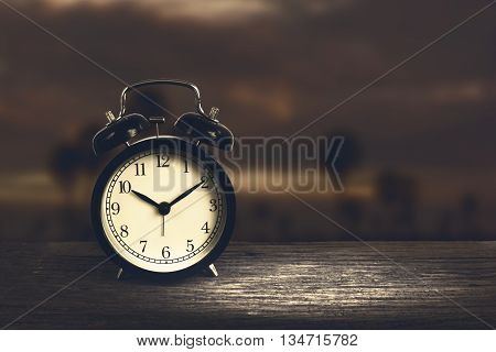 Alarm Clock On Wood With Blurry Night Sky In Background