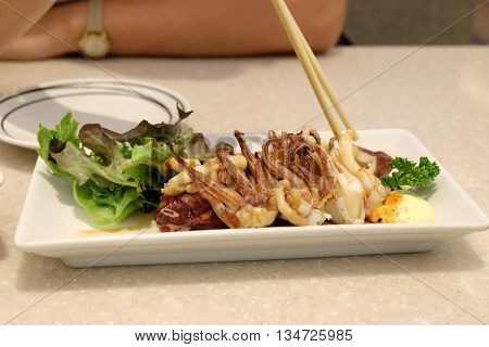 Eating Squid teriyaki grill in restaurant thai