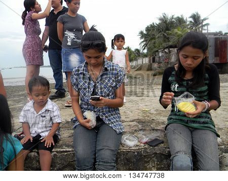CEBU CITY, CEBU / PHILIPPINES - JULY 30, 2011: People enjoy eating sliced pineapple at a picnic at the seashore of Cebu.