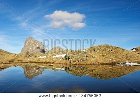 Midi Dossau Peak reflected in a lake. Ossau Valley, Pyrenees National Park, Pyrenees, France.