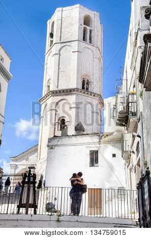 Monte Sant Angelo Italy August 17 2014: a young couple hugging under the white Angioina tower