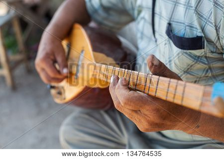 Close up shot of a man playing a Tatar instrument called "baglama".