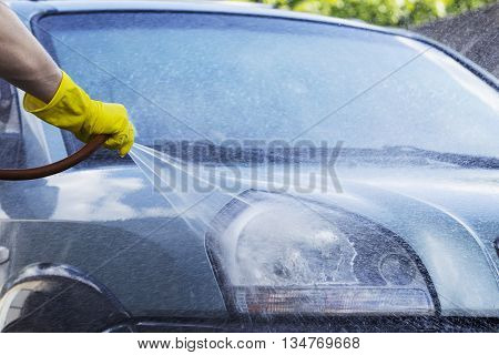 blue car is washing in soap suds
