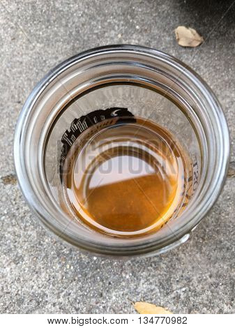 An almost empty glass with a bit of beer at the bottom