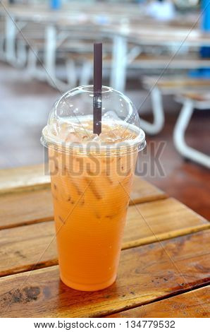 Milk Tea in plastic glass - on wooden table