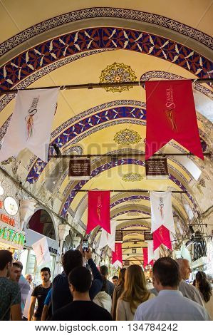 ISTANBUL TURKEY - JUNE 19 2015: Tourists visiting the Grand Bazaar in Istanbul Turkey. The Grand Bazaar is the oldest and the largest covered market in the world with 61 covered streets and over 3000 shops.