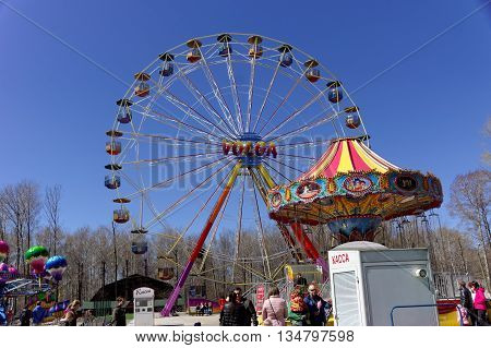 Nizhny Novgorod, Russia - May 2.2013. Ferris wheel in the park Switzerland. On a warm spring day, the townspeople with children having fun ride on the carousel