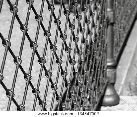 indistinct fragment of an old iron fence closeup in park in outdoor and a blank space of monochrome tone