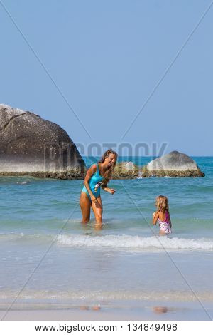 Mum with daughter on the beach in Thailand