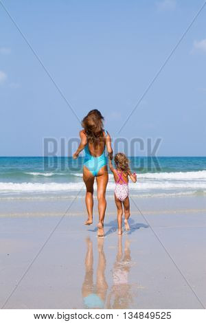 Mum with daughter on the beach in Thailand