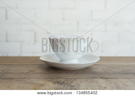 Beautiful hot cappuccino on wooden table background