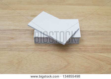 blank business cards stack up on wooden table