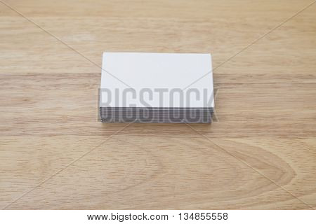 blank business cards stack up on wooden table