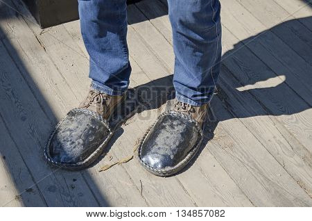Irkutsk region Russia - May10 2015: Iron sculpture home slippers for men on wooden floor
